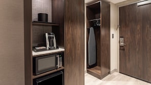 A modern kitchen with a microwave, coffee maker, and storage cabinets. - Holiday Inn Boston Logan Airport - Chelsea by IHG (Chelsea)