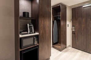 A modern kitchen with a microwave, coffee maker, and storage cabinets. - Holiday Inn Boston Logan Airport - Chelsea by IHG (Chelsea)