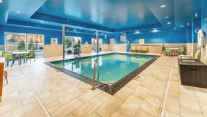 An indoor swimming pool with a blue ceiling, tiled floor, and a pool lift sign. - Holiday Inn Express & Suites Nashville North - Springfield by IHG (Springfield)