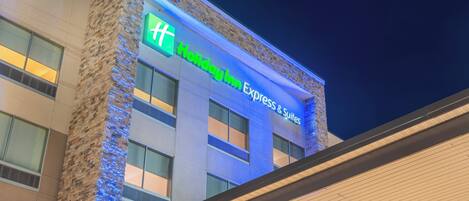 A Holiday Inn Express & Suites building with a prominent sign and a brick facade.