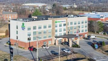 A Holiday Inn Express & Suites hotel with a parking lot and a road in the foreground.