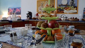 Una mesa de comedor con un frutero escalonado, una figurita de muñeco de nieve y varios utensilios de cocina.