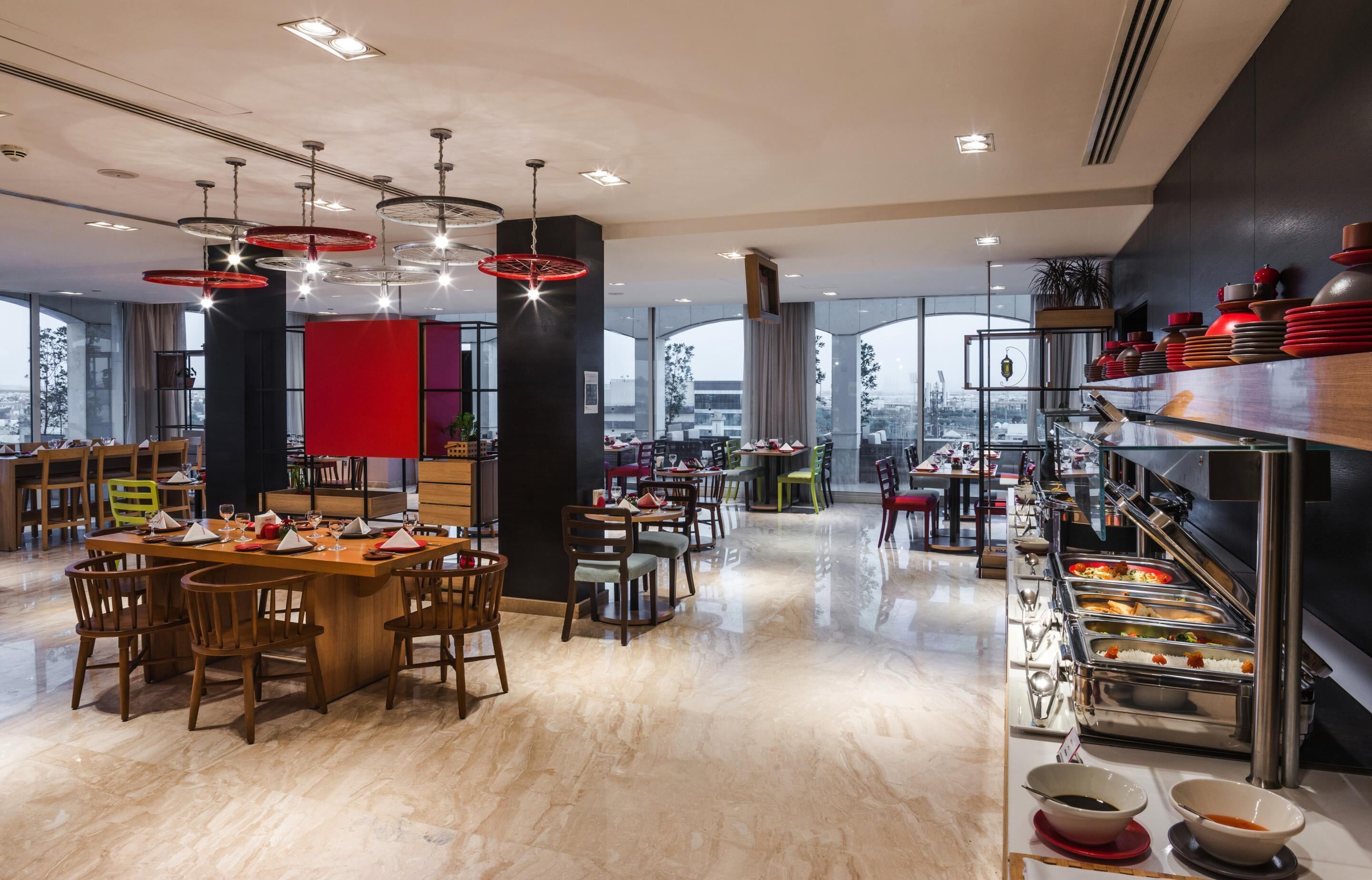 Un comedor moderno con varias mesas, sillas y un bufé.