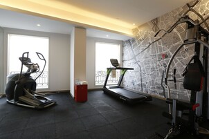 A gym with treadmills, an elliptical, and a wall map.