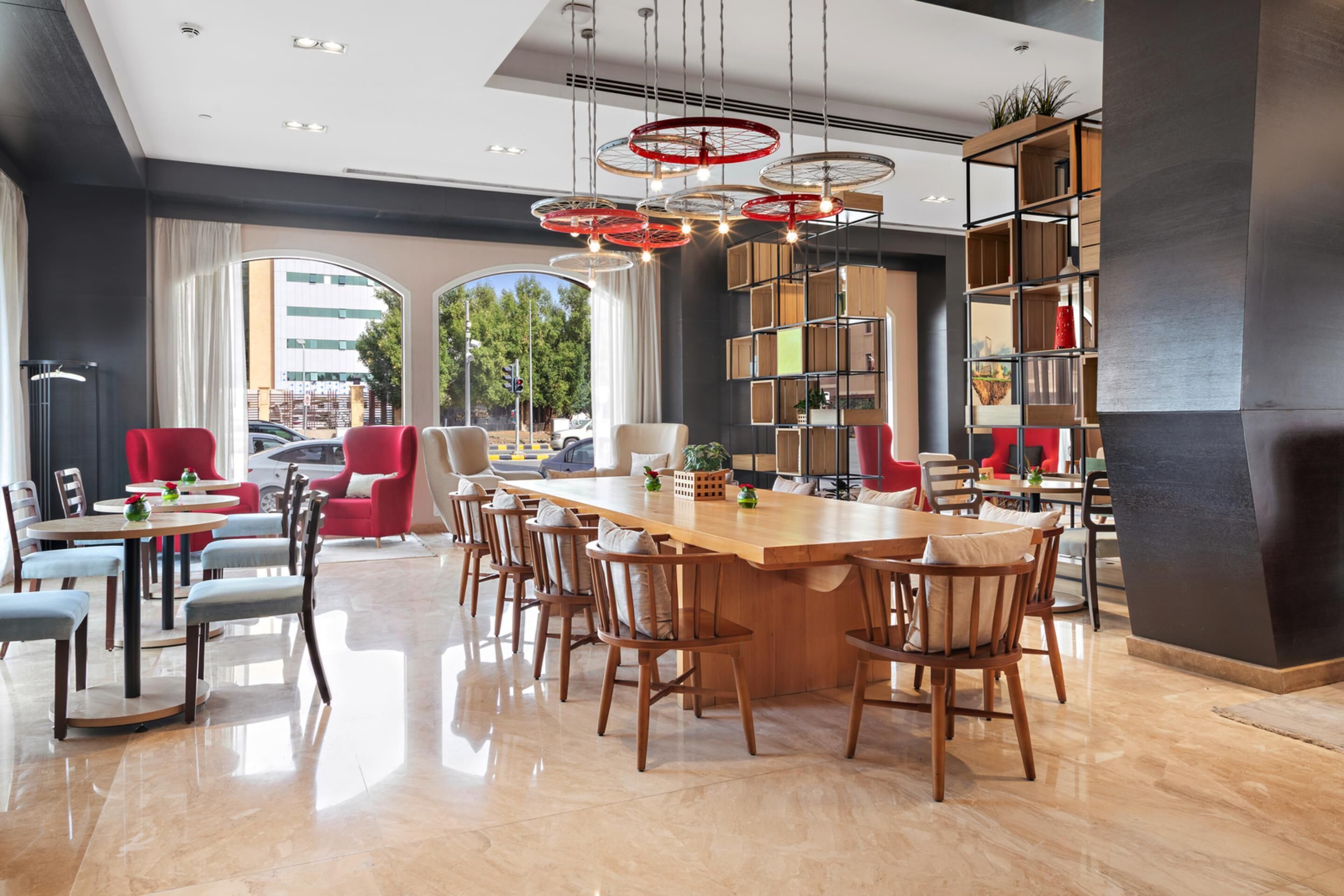 A modern dining area with a central island, multiple seating options, and a large bookshelf.