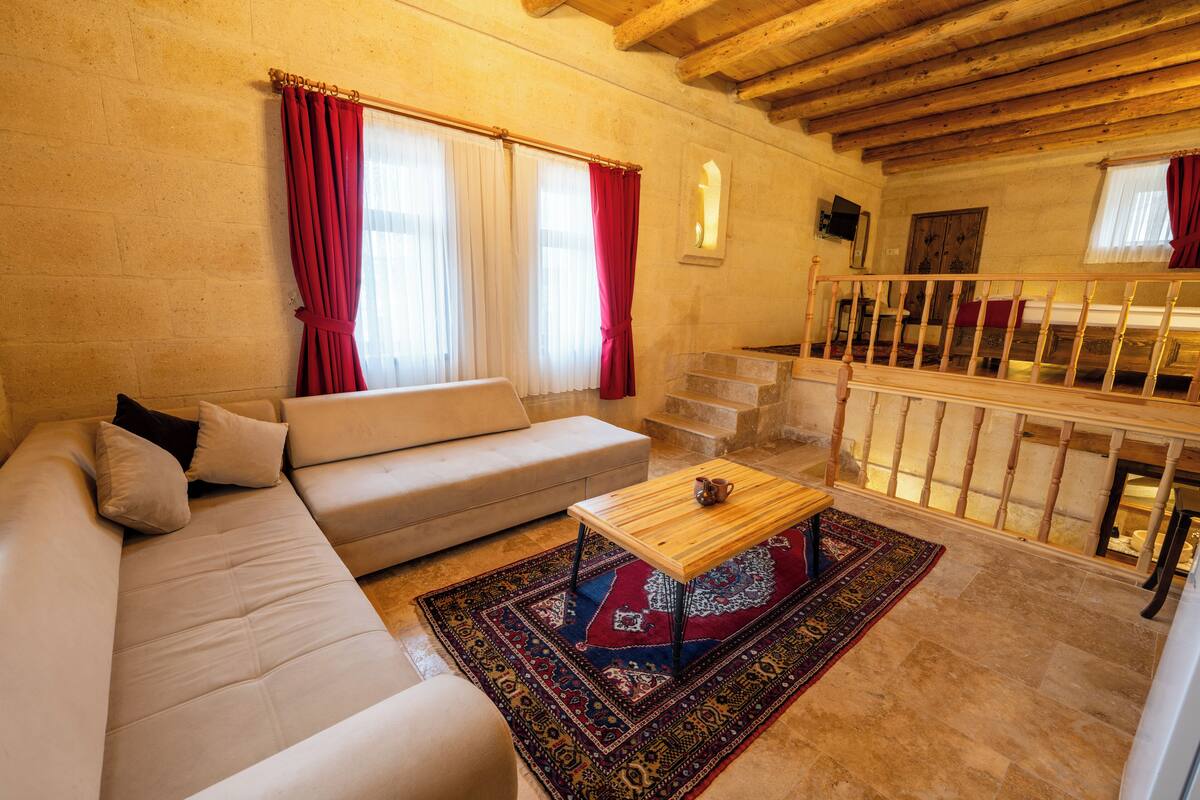 A living room with a sofa, a wooden coffee table, and a patterned rug.