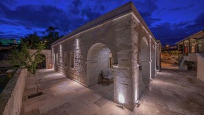 A stone building with arches and a tiled floor, illuminated by artificial lighting. - Asyada Suites Hotel (Ürgüp)