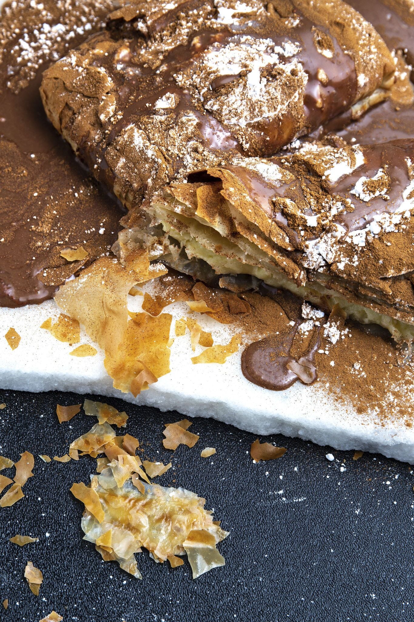 Ein Dessert mit Schokoladensauce und Puderzucker.