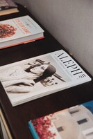 Una revista titulada 'ALEPH' sobre una mesa con un libro y un bolígrafo a un lado.