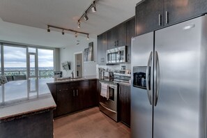 Exclusive Condo, 2 Bedrooms, Mountain View | Private kitchen | Full-size fridge, microwave, oven, stovetop - Suite Digs Vetro (Calgary)