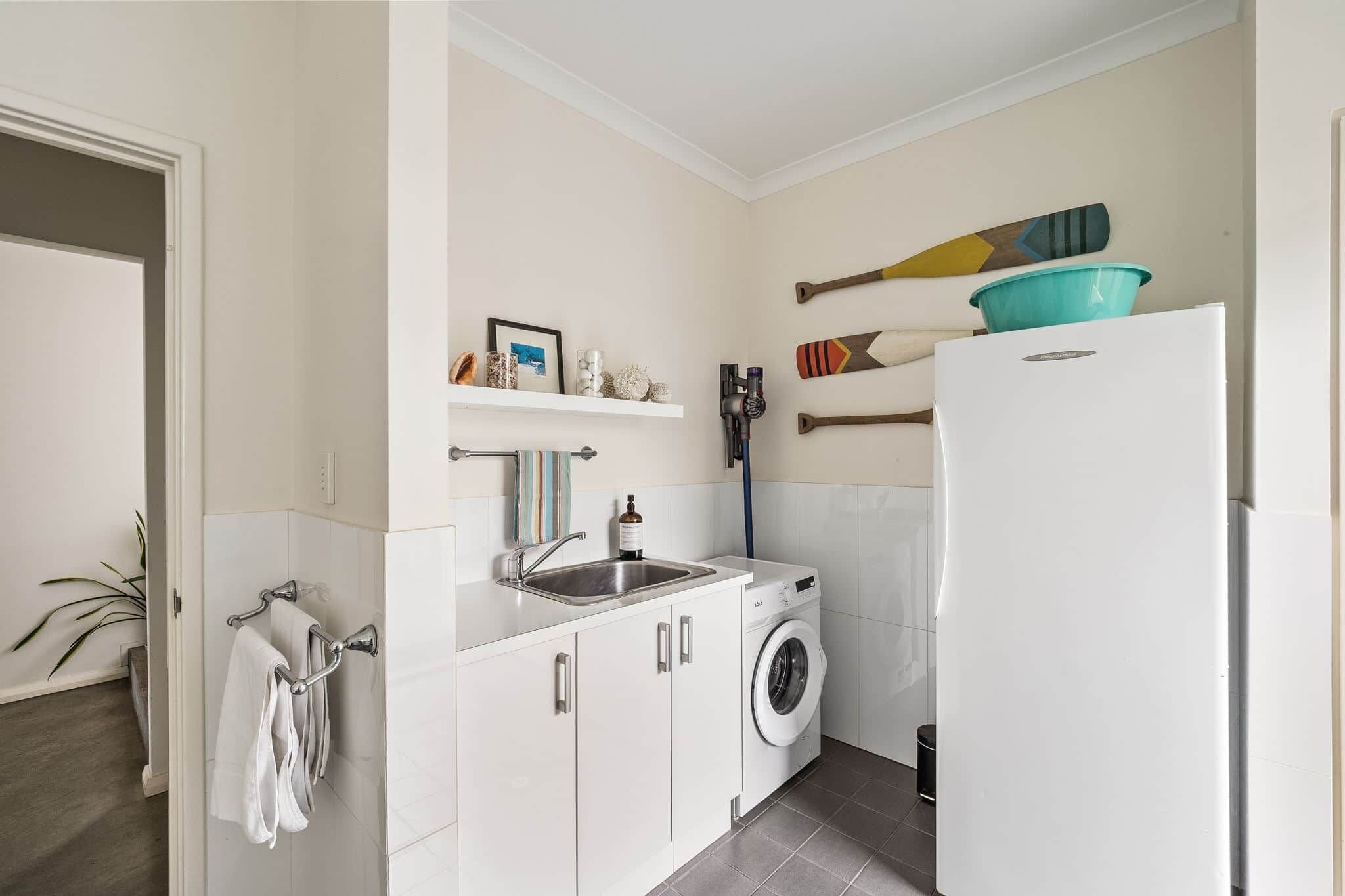 A compact kitchen with a washing machine, a sink, and a refrigerator.