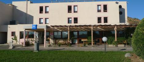 A hotel with a sign reading "ibis budget HOTEL" and a sign for "ibis budget Florbonne Sud."