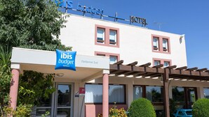 Un hôtel avec une enseigne indiquant « ibis budget » et « Narbonne Sud ».