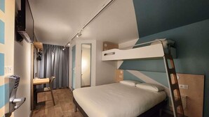 Habitación con literas, un escritorio, televisor montado en la pared y suelo de madera.