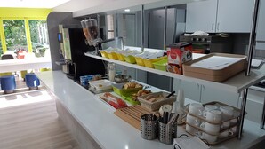 Un área de cocina moderna con una cafetera, diversos alimentos y electrodomésticos.