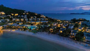 Ein Küstenresort mit Strandvillen, einem Swimmingpool und einem Strand.