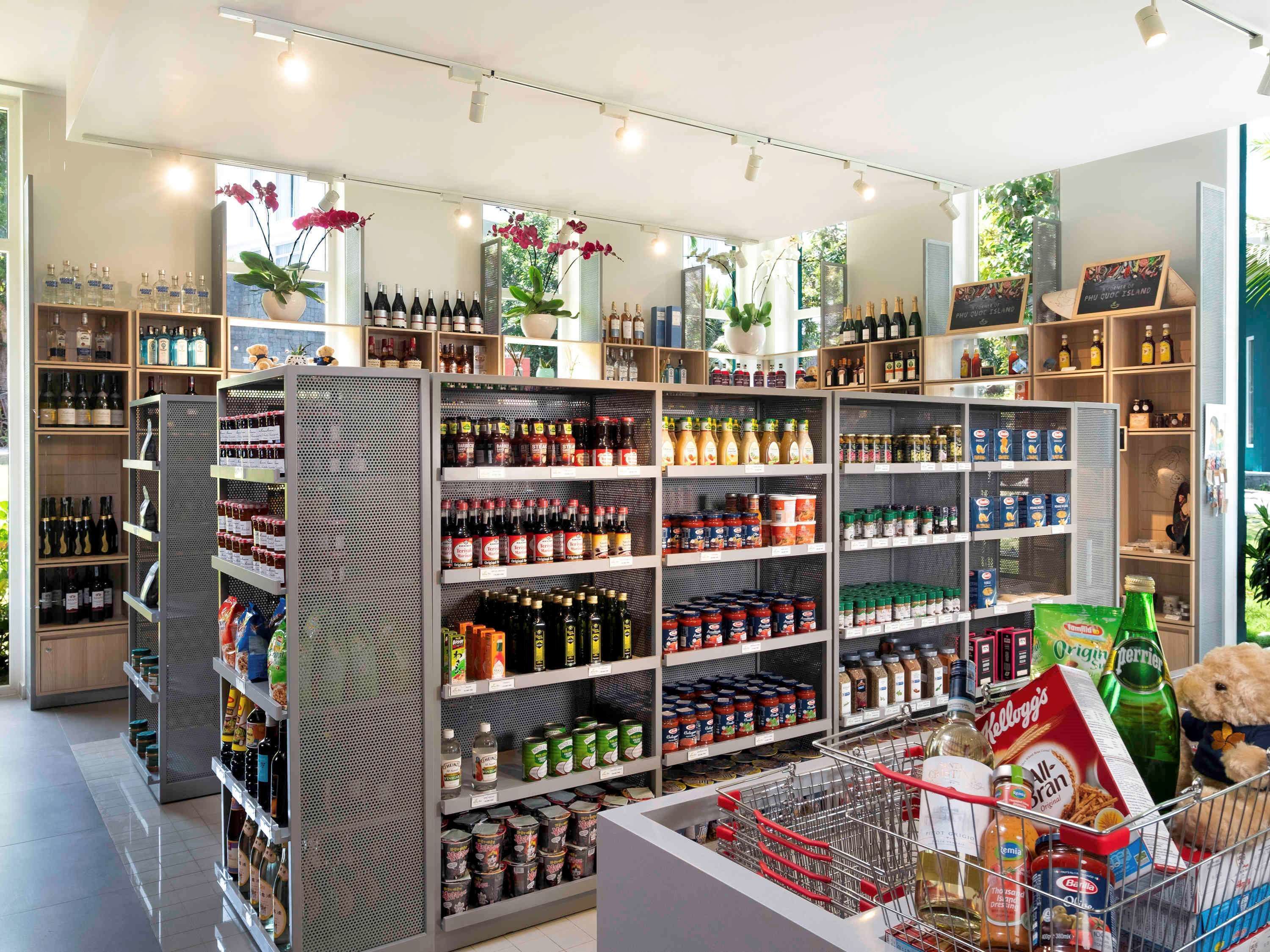 A grocery store with shelves stocked with various products, a shopping cart with items, and a teddy bear.
