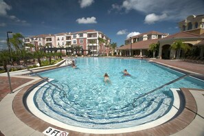 Piscina con indicador de profundidad de 0,9 metros, rodeada de un suelo de baldosas y palmeras.