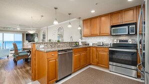 A modern kitchen with wooden cabinets, stainless steel appliances, and a large island.