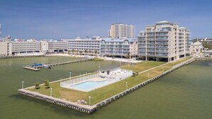 A waterfront hotel with multiple buildings, a swimming pool, and a dock area.