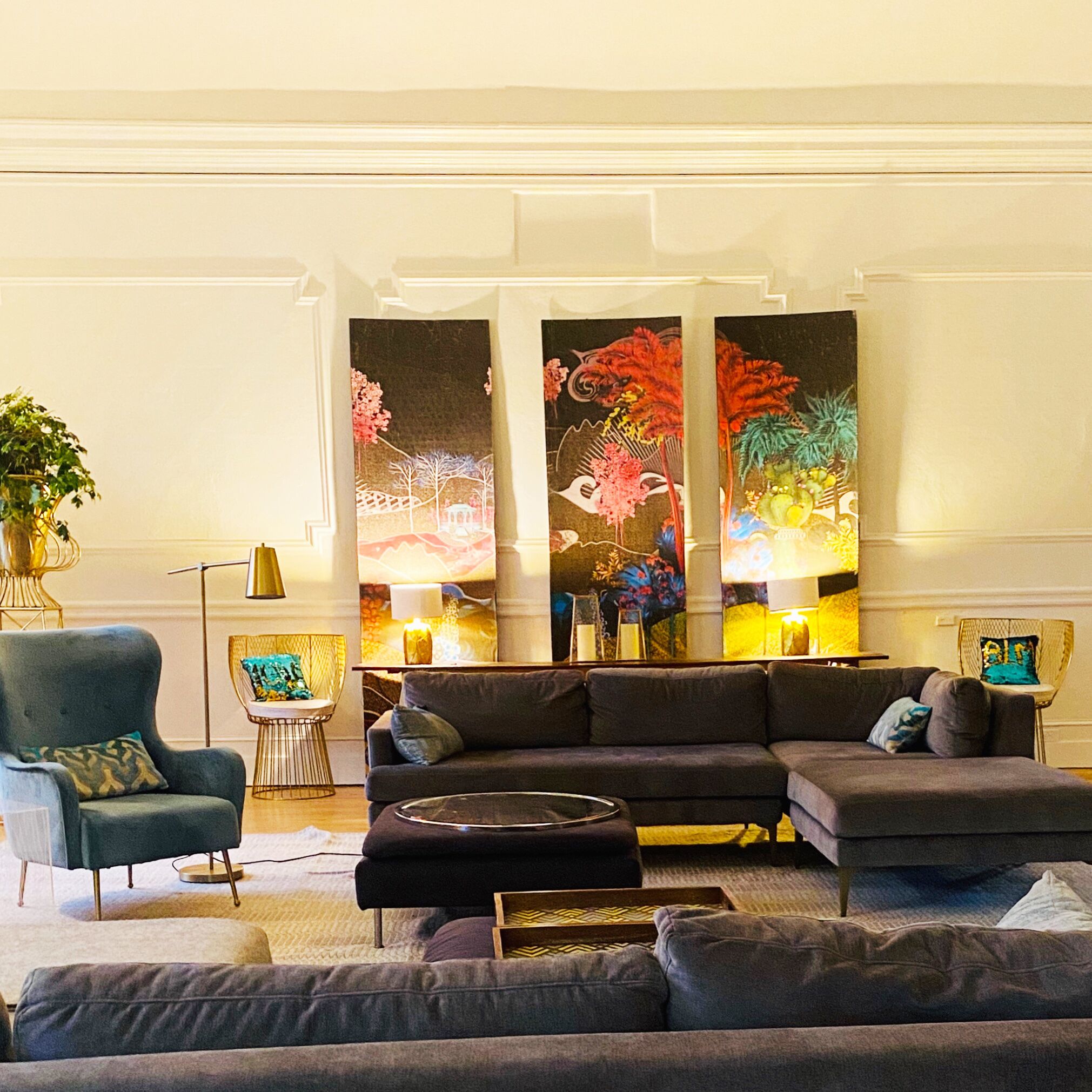 Un salon moderne avec un canapé d’angle, une petite table d’appoint et un lampadaire.