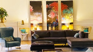 Ein modernes Wohnzimmer mit einem Ecksofa, einem kleinen Beistelltisch und einer Stehlampe.