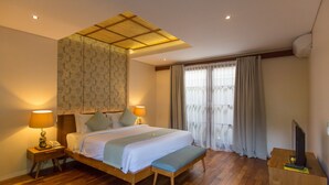 A hotel room with a wooden bed, two bedside lamps, a bench, a TV on a wooden stand, and a window with curtains. - 1BR Villa, DAILY HOUSE KEEPING! - W/Swimming Pool! (Seminyak)