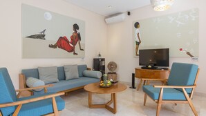 A modern living room with a sofa, two armchairs, a coffee table, and artwork on the walls. - 2BR Villa, Near Padma Beach - W/DAILY HOUSE KEEPING!  (Seminyak)