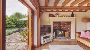 Ein gemütliches Wohnzimmer mit Kamin, Fernseher und einer bequemen Sitzecke.