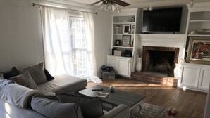 Een woonkamer met een bank, salontafel en een open haard.