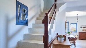 A staircase with a wooden handrail leading to a dining area with a table and chairs. - Villa with private wind-sheltered pool, fab seaviews, walking distance to Beach (Paros)