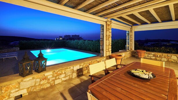 A covered outdoor area with a pool, stone walls, wooden furniture, and lanterns. - Villa with private wind-sheltered pool, fab seaviews, walking distance to Beach (Paros)