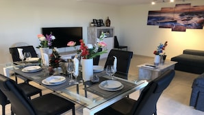A modern dining area with a glass table, black chairs, and floral centerpieces. - SENSATIONAL SEMI-DETACHED HOUSE TO RELEASE .... POOL OF 1.00 m2. WITH CIUCUITO SPA. (Sant Jordi, Castellón)