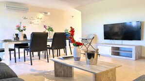 A modern living room with a dining area, a flat-screen TV, and decorative wall art. - SENSATIONAL SEMI-DETACHED HOUSE TO RELEASE .... POOL OF 1.00 m2. WITH CIUCUITO SPA. (Sant Jordi, Castellón)