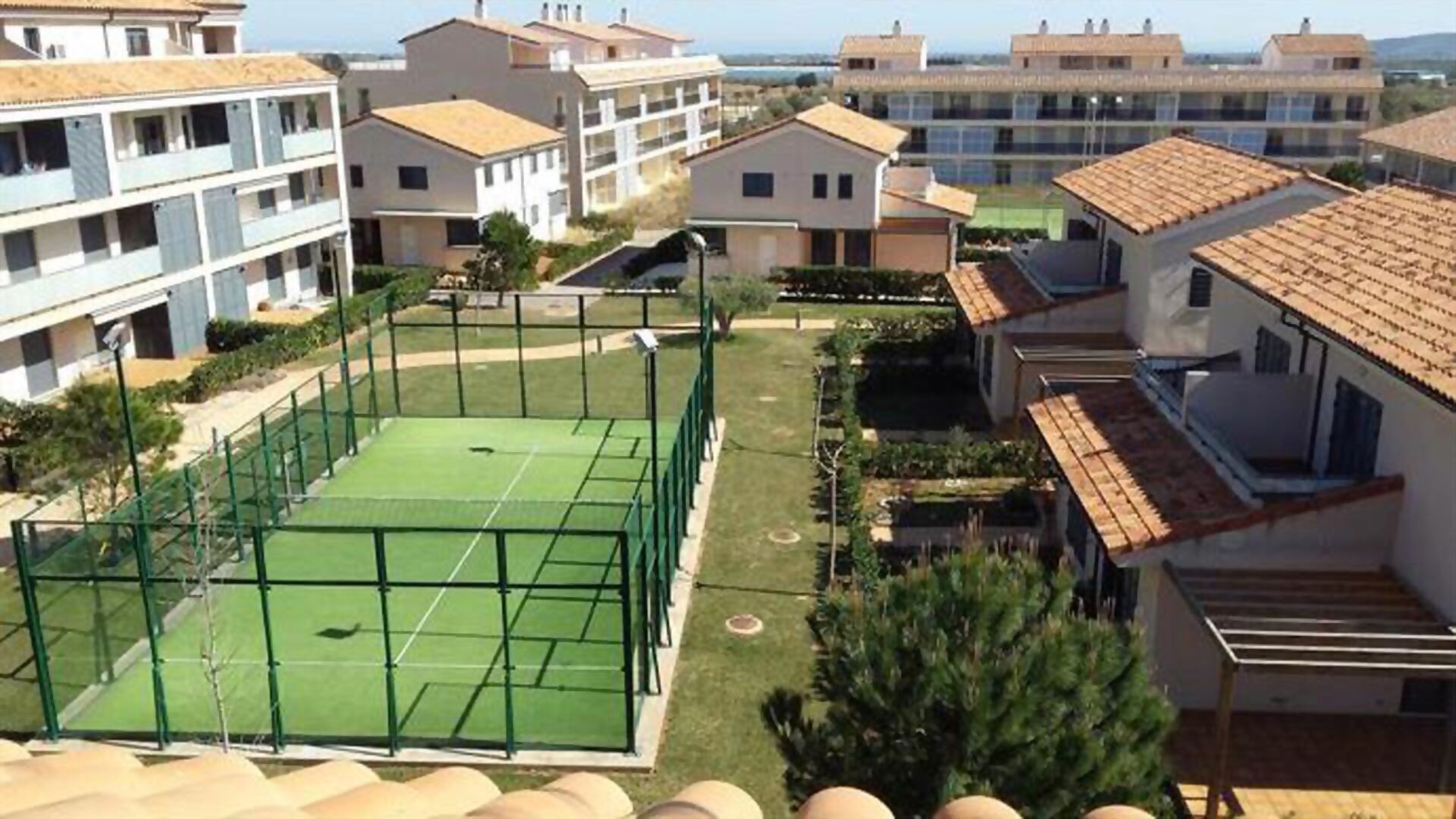 Zona residencial com quadra de tênis, cercada por casas.