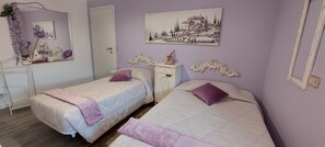 A bedroom with two beds, a dresser, a mirror, and a painting on the wall.