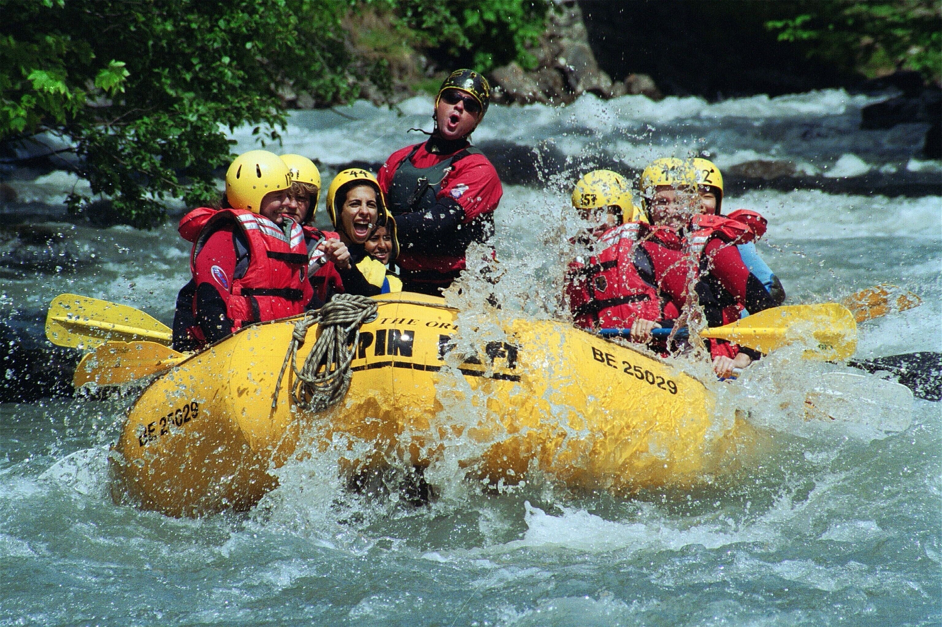 A group of people in a yellow raft navigating a river.