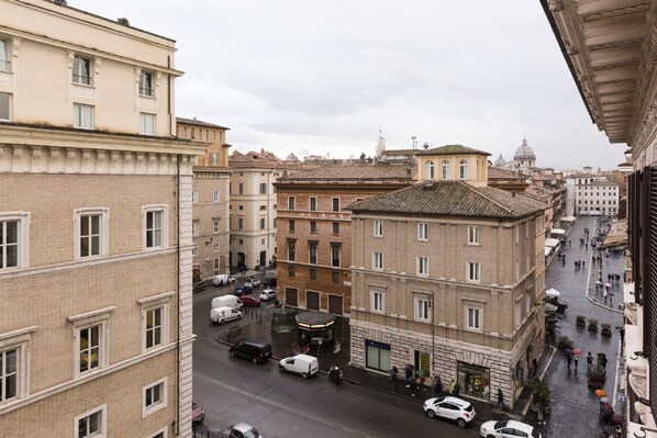 A street view with buildings, vehicles, and pedestrians. - Nice Apartment Navona Square (Rome)