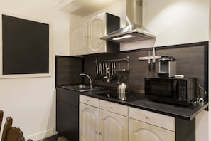 Una cucina moderna con una cappa aspirante in acciaio inossidabile, un forno a microonde e un bollitore sul piano di lavoro.