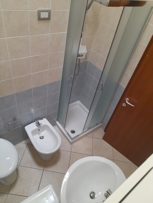 A bathroom with a shower, bidet, toilet, and bathtub.