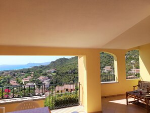 A balcony with a view of a hillside town and the sea. - Trilocale Stella (Costa Rei)