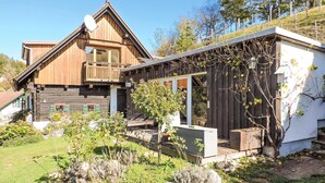 A wooden house with a balcony and a separate modern extension with a glass facade. - schoenes Ferienhaus-Grossklein (Grossklein)