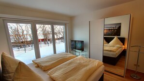 A bedroom with a bed, a television, and a large mirror. - Villa SEE-RESIDENZ - VILLA SEE-RESIDENZ (Malchow)