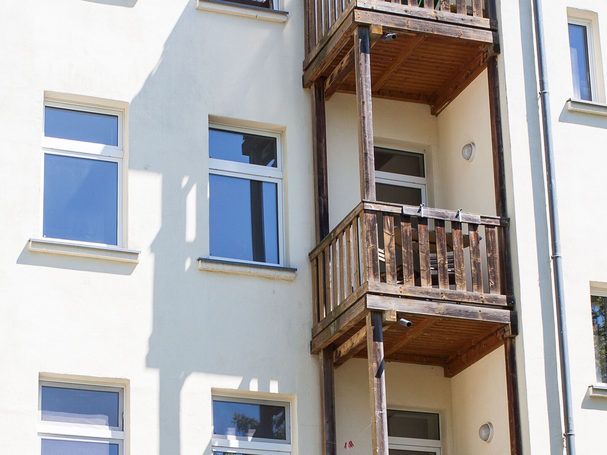 A multi-story building with balconies, windows, and a visible door.