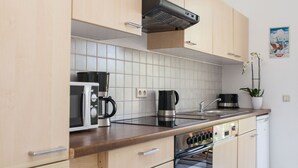 Une cuisine moderne dotée de meubles en bois, d’un four à micro-ondes, d’une machine à café et d’un four traditionnel.
