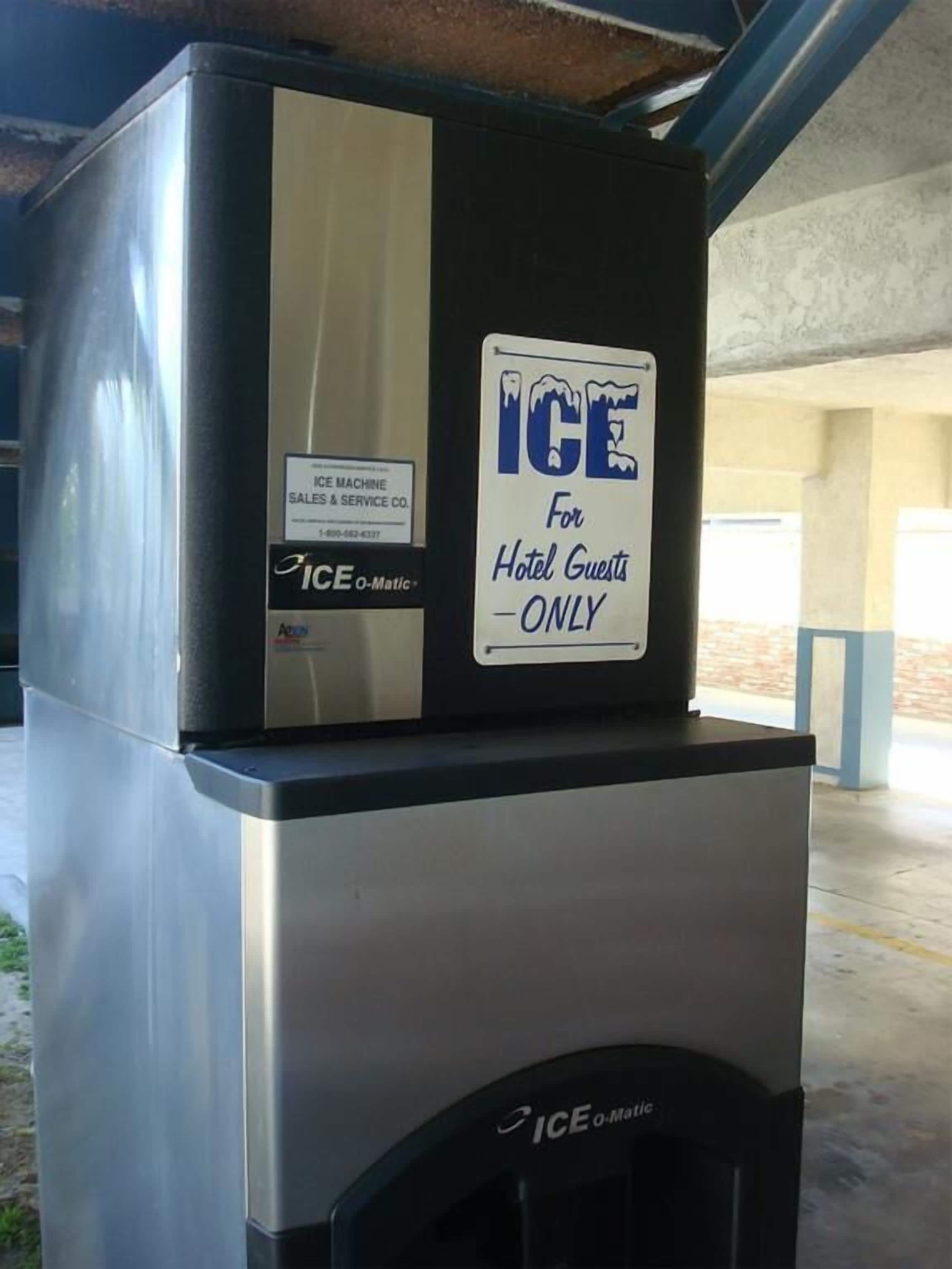 A commercial ice machine with a sign indicating it is for hotel guests only.