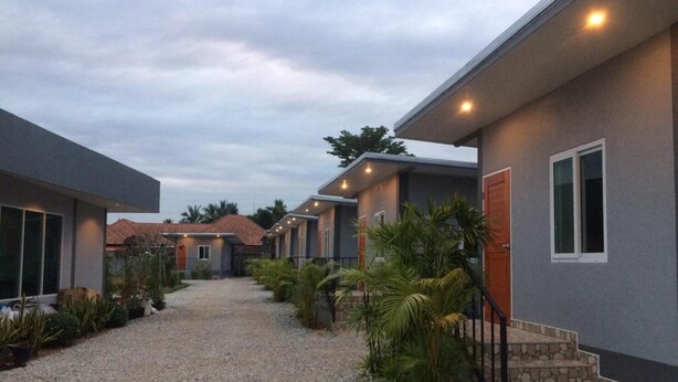 Una hilera de casas modernas con un camino de grava y plantas en macetas.