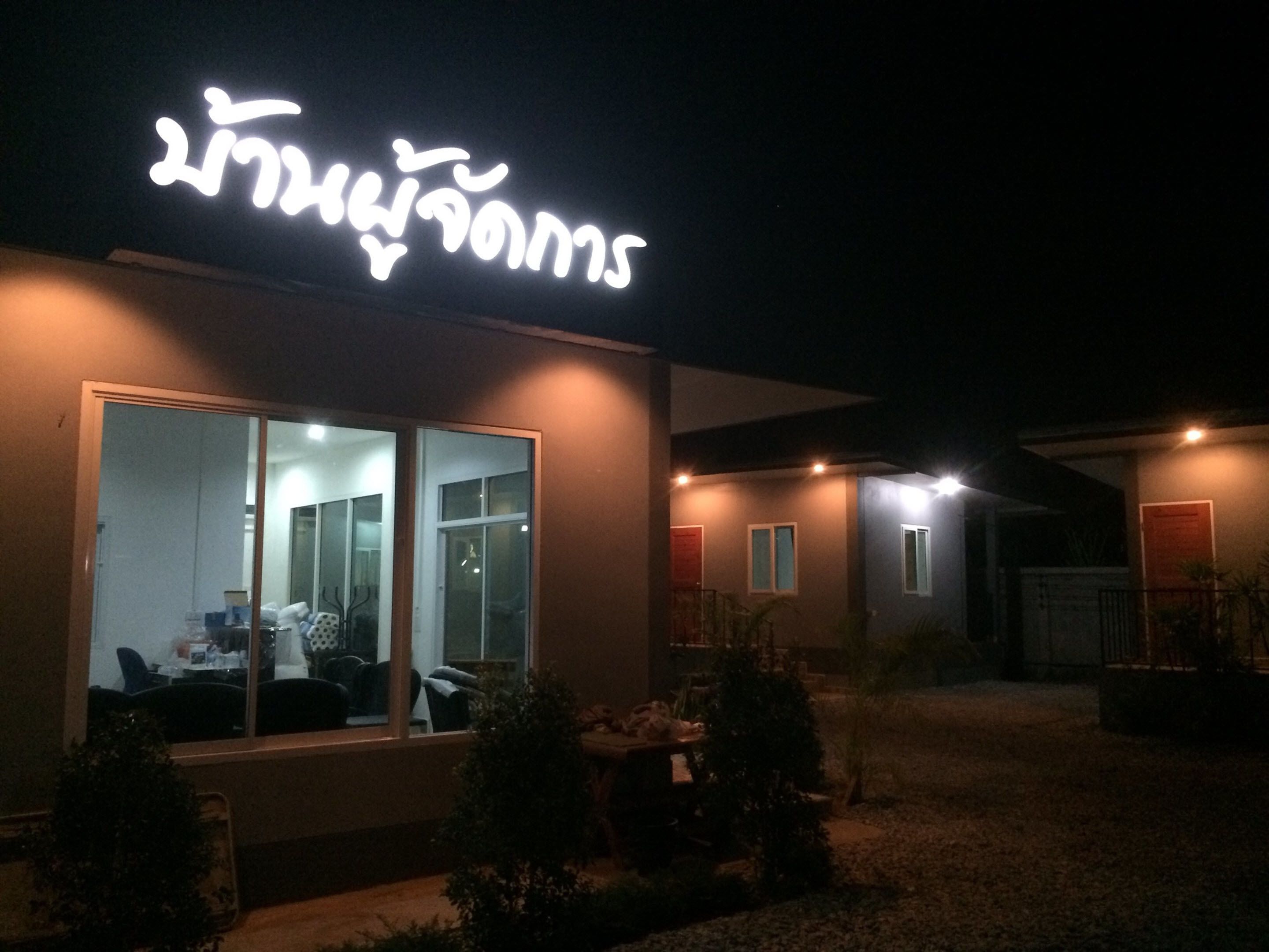 A modern building with a large illuminated sign, large windows, and a well-lit entrance area.