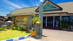 Un edificio con un cartel que dice "Berkadia Abadi" y una maceta amarilla grande con una palmera.
