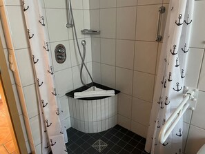 A small, tiled bathroom with a shower, a towel rack, and a sink. - Suite Anna with terrace 25 u (SA) - Usedom Suites 25***, beach 100 m (Karlshagen)